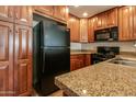 View of kitchen with black appliances and ample wood cabinets at 5450 E Deer Valley Dr # 4201, Phoenix, AZ 85054