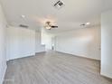 Bright living room with gray vinyl plank flooring and ceiling fan at 10073 W Mission Dr, Arizona City, AZ 85123