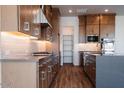 Modern kitchen featuring dark wood cabinets, stainless steel appliances, and subway tile backsplash at 1364 E Nolan Pl, Chandler, AZ 85249