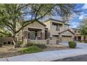 Two-story house with stone accents, landscaping, and a three-car garage at 15526 W Minnezona Ave, Goodyear, AZ 85395