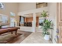 Living room with a pool table and high ceilings at 15526 W Minnezona Ave, Goodyear, AZ 85395