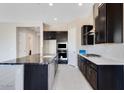 Spacious kitchen with dark cabinetry, granite countertops, and stainless steel appliances at 18104 W Silverwood Dr, Goodyear, AZ 85338