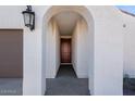 Covered entryway with arched entry and elegant light fixture at 18111 W Hiddenview Dr, Goodyear, AZ 85338