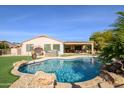 Relaxing pool area featuring a kidney-shaped pool and grassy area at 21705 N Black Bear Lodge Dr, Surprise, AZ 85387