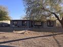 House features a gray exterior, walkway, and mature trees at 303 W 13Th St, Eloy, AZ 85131