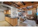 Open living area with exposed beams, kitchen, and staircase at 304 W Roosevelt St # 102, Phoenix, AZ 85003