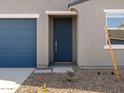 Close up of the front door, showing the desert landscaping, gray color and blue door at 3403 E Audrey Dr, San Tan Valley, AZ 85143