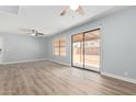 Living room featuring laminate flooring, sliding glass doors, and neutral walls at 3745 W Carol Ann Way, Phoenix, AZ 85053