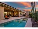 Relaxing backyard oasis with a sparkling pool, fire pit, and patio furniture at 40822 N Harbour Town Way, Anthem, AZ 85086