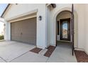 Front entry with brown door and garage at 4415 N Sidney St, Buckeye, AZ 85396