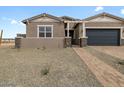 Charming single-story home with a brick driveway, desert landscaping and a dark blue garage door at 4727 N 177Th Dr, Goodyear, AZ 85395