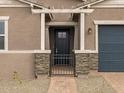 Close up of the home's entrance and brick walkway, framed by stone pillars and metal gate at 4727 N 177Th Dr, Goodyear, AZ 85395