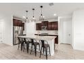 Modern kitchen with an island, stainless steel appliances, and dark cabinets at 5644 W Jackalope Ln, Laveen, AZ 85339