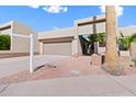 Front view of a tan house with a gated entry and brick walkway at 9025 N 86Th Pl, Scottsdale, AZ 85258