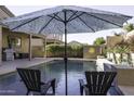 Inviting backyard pool with lounge chairs and patio umbrella at 1240 W Falls Canyon Dr, Casa Grande, AZ 85122