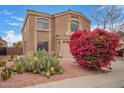 Charming home featuring a neutral color palette, tile roof, an attached two-car garage, bougainvillea and cactus at 12474 W Redfield Rd, El Mirage, AZ 85335