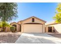 Single-story house with a two-car garage and desert landscaping at 13353 W Port Royale Ln, Surprise, AZ 85379