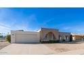 Mid-century modern home with a white garage door and brick facade at 14202 N Lakeforest Dr, Sun City, AZ 85351