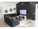 Living room with dark-grey couch and a large TV at 1435 S Spartan St, Gilbert, AZ 85233