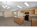 Open kitchen with island and view into dining area at 15466 W Laurel Ln, Surprise, AZ 85379