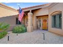 Welcoming entryway with a wooden door and nicely landscaped area at 19035 E Tonto Trl, Rio Verde, AZ 85263