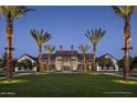 Elegant community clubhouse with palm trees and nighttime lighting at 1928 W Rowel Rd, Phoenix, AZ 85085