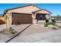 Charming house with a two-car garage, stone accents, and neatly landscaped yard at 24 S 175Th Ave, Goodyear, AZ 85338