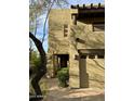 Tan stucco two-story home with a walkway leading to the entrance at 28414 N 101St Pl, Scottsdale, AZ 85262