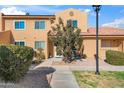 Front view of a two-story tan condo with walkway and landscaping at 3511 E Baseline Rd # 1243, Phoenix, AZ 85042