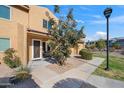 Tan two-story condo with a tree, walkway, and lamppost at 3511 E Baseline Rd # 1243, Phoenix, AZ 85042