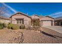 Single-story home with landscaped yard and two-car garage at 44562 W Sedona Trl, Maricopa, AZ 85139