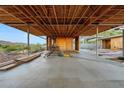 Open-concept interior under construction with wood beams and concrete flooring at 4975 E Mcdonald Dr, Paradise Valley, AZ 85253