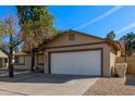 House exterior showcasing a white garage door and mature tree at 6207 W Acoma Dr, Glendale, AZ 85306