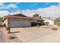 Brick ranch house with landscaped yard, two-car garage, and driveway at 910 S Portland Cir, Mesa, AZ 85206