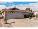 Brick ranch house with landscaped yard, two-car garage, and driveway at 910 S Portland Cir, Mesa, AZ 85206