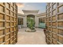 Inviting courtyard entry with large wooden doors and a tranquil cactus garden at 9697 E Preserve Way, Scottsdale, AZ 85262