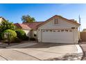 Single-story home with red tile roof, two-car garage, and well-manicured lawn at 1201 E Campbell Ave, Gilbert, AZ 85234