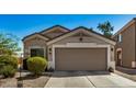 Tan house with a two-car garage and desert landscaping at 12443 W Via Camille Dr, El Mirage, AZ 85335