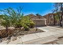 Tan house with a two-car garage and small front yard at 12443 W Via Camille Dr, El Mirage, AZ 85335