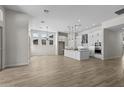 Open-concept kitchen and living space featuring white cabinets, stainless steel appliances, and pendant lighting at 32496 N 135Th Dr, Peoria, AZ 85383