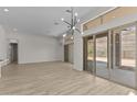 Spacious living room showcasing wood-look tile flooring and a modern chandelier at 32496 N 135Th Dr, Peoria, AZ 85383