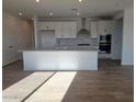 Modern kitchen with white cabinets, granite counters, and island at 33364 N 132Nd Dr, Peoria, AZ 85383