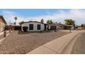 Front view of a single story home showcasing its white exterior and rock landscaping at 4639 W Becker Ln, Glendale, AZ 85304