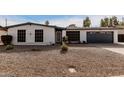 Single story home with white exterior, gray garage door, and well-maintained landscaping at 4639 W Becker Ln, Glendale, AZ 85304