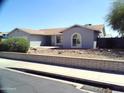 Single-story home with gray exterior, landscaped yard, and a two-car garage at 5843 W Crocus Dr, Glendale, AZ 85306