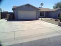 Two-car garage with a long driveway and a spacious front yard at 5843 W Crocus Dr, Glendale, AZ 85306