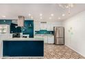 Modern kitchen with teal accents, stainless steel appliances, and a breakfast bar at 10517 W Diana Ave, Peoria, AZ 85345