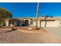 Tan one-story house with tile roof, landscaping, and driveway at 13708 W Robertson Dr, Sun City West, AZ 85375