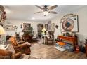 Living room features hardwood floors, a large TV, comfortable armchairs, and western decor at 19019 N Camino Del Sol --, Sun City West, AZ 85375