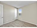 Comfortable bedroom with neutral paint, carpeted floors, window, and white doors at 19026 W Stella Ave, Waddell, AZ 85355